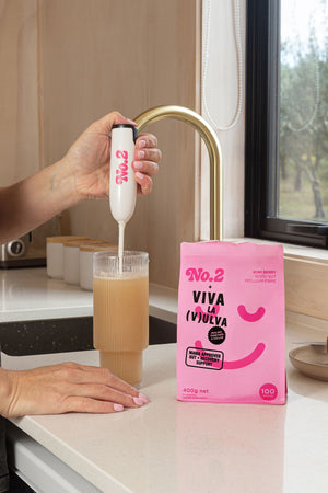 Person mixing No2 Kiwiberry psyllium with a No2 whizz stick on a kitchen bench.