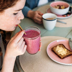 Girl drinking kiwi berry smoothie containing psyllium husk powder