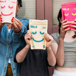 Alice's family holding up No.2 packets showing faces